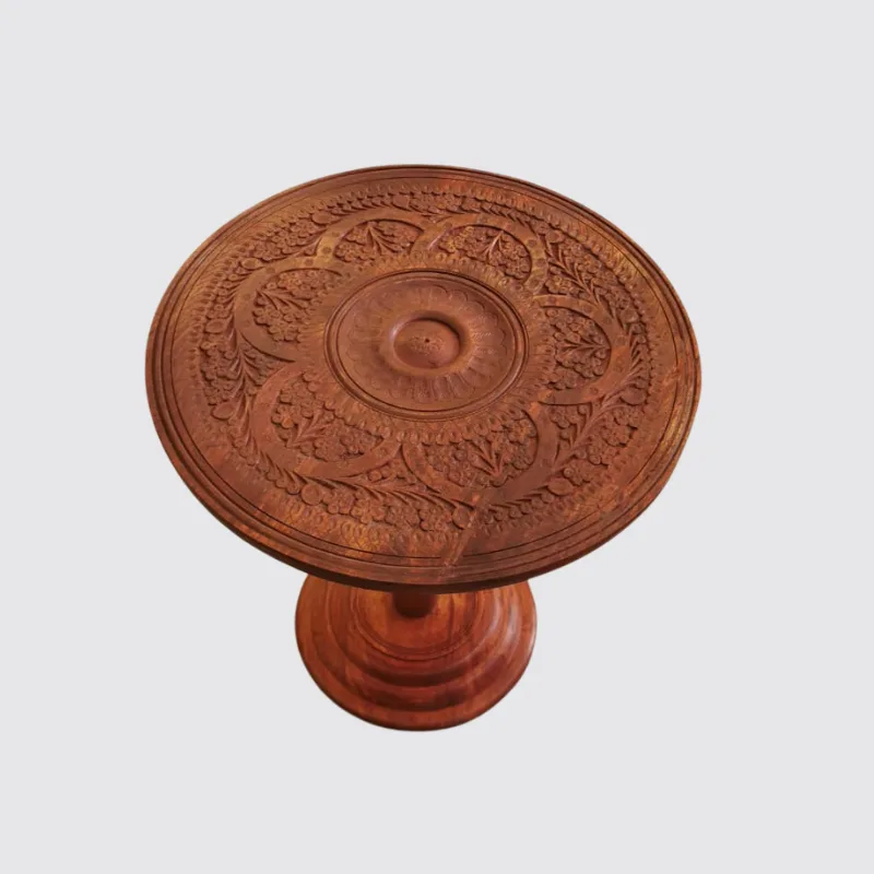 Round sheesham side table with dense floral carving across the top and pedestal