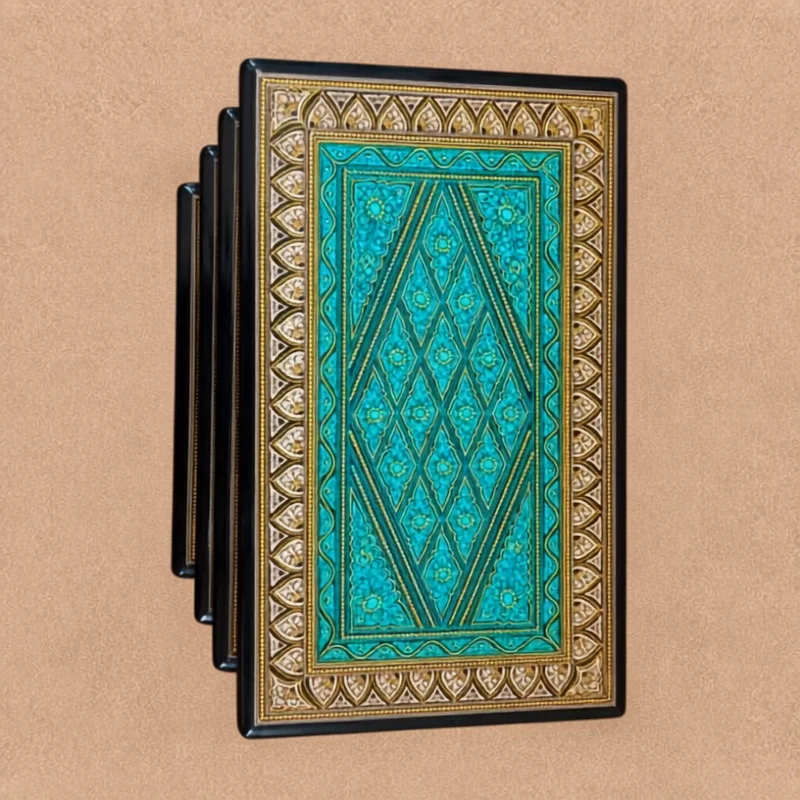 Nesting table with a teal lacquer top and a gold patterned border