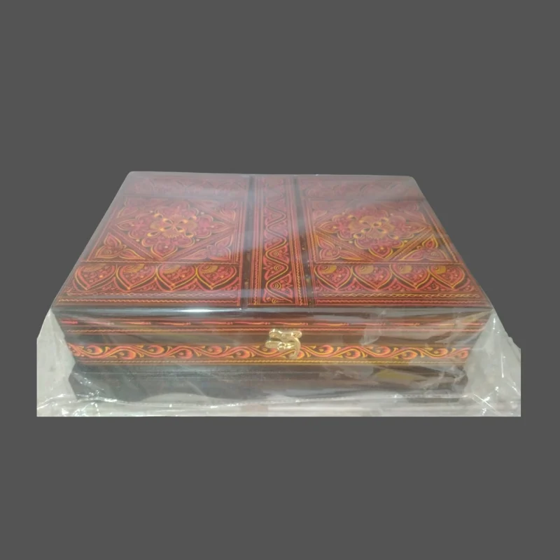 Red and gold lacquered Quran box open to show the red cloth lining