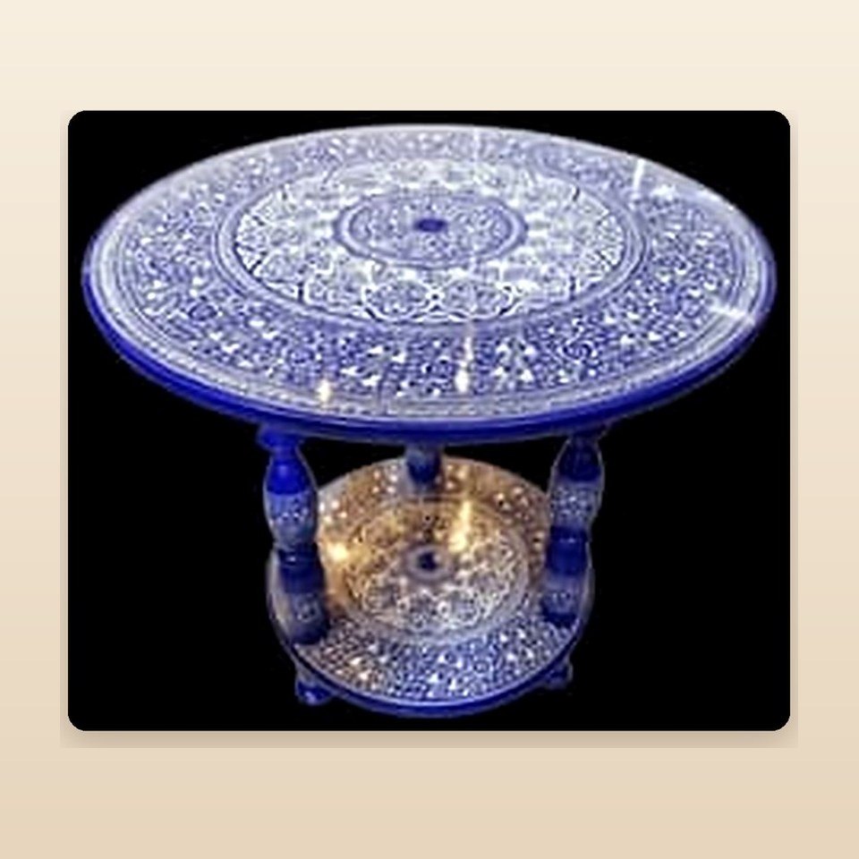 Round table with a deep blue top covered in fine white naqshi scratchwork