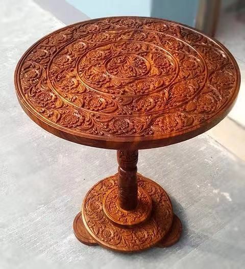Round carved wooden side table on a turned pedestal base