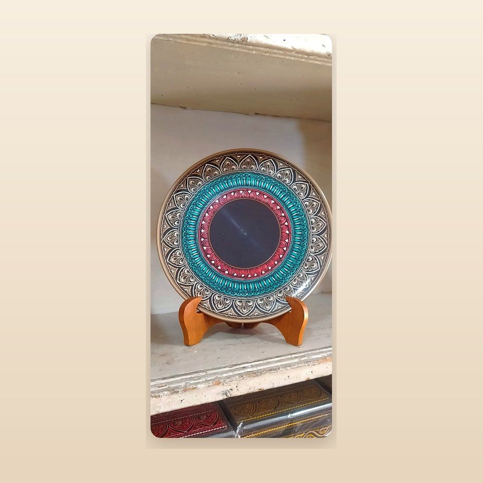 Turned wooden display plate with concentric patterned rings on a wooden stand