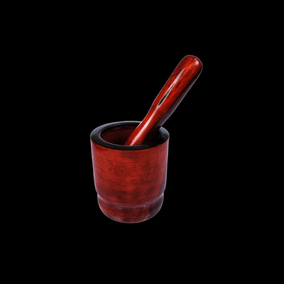Red-polished wooden mortar with the pestle standing inside it