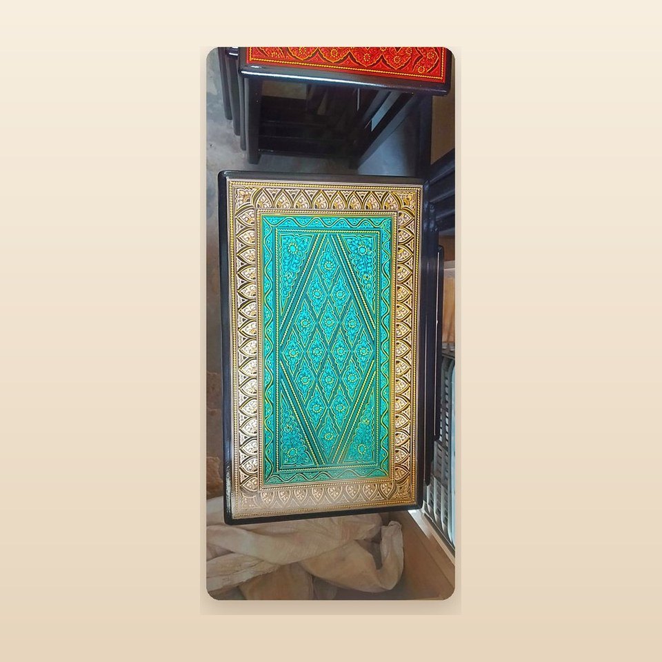 Nesting table with a teal lacquer top and a gold patterned border