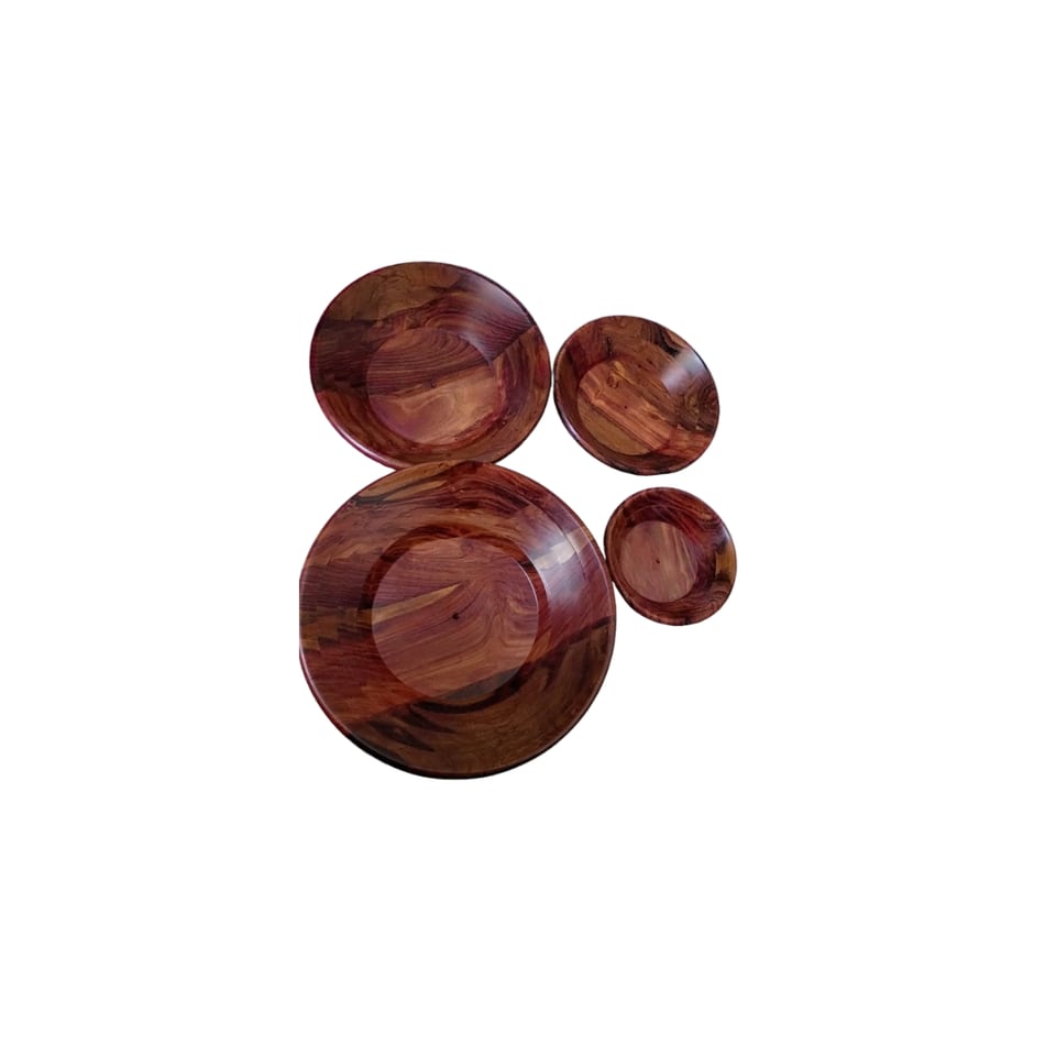 Stack of three round sheesham serving plates with two wooden spoons resting on top