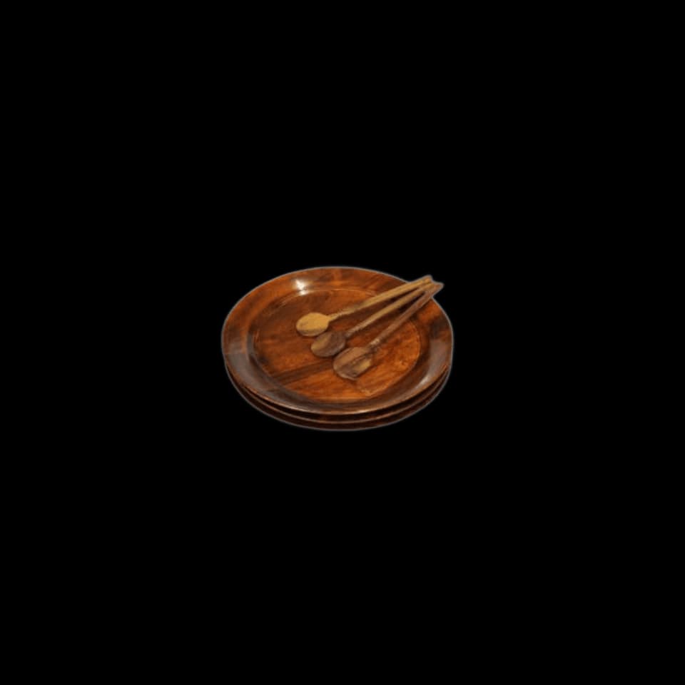 Three round sheesham serving plates stacked with two wooden spoons resting on top