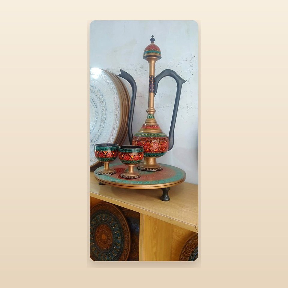 Naqshi surahi with matching cups arranged on a round patterned tray