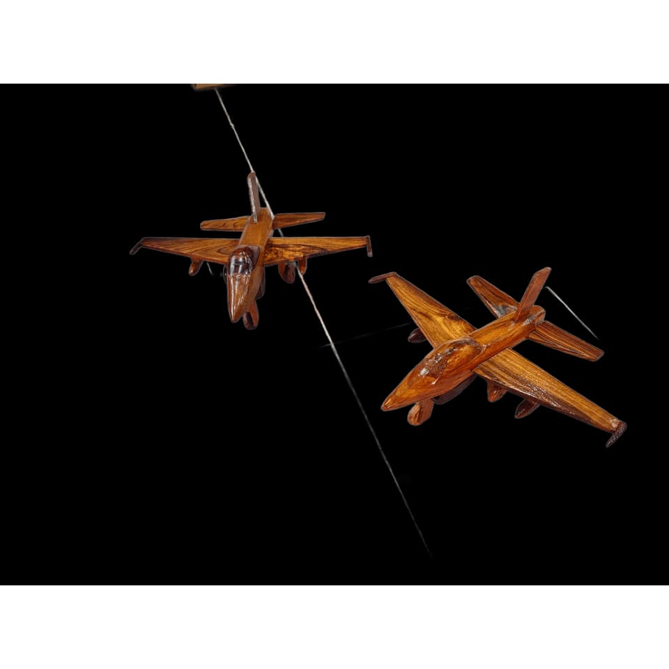 Two hand-carved sheesham wood fighter jet models with swept wings and twin tail fins on a marble surface
