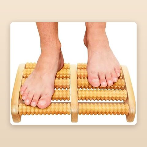 Feet rolling on the wooden foot massager with dual rows of carved wooden rollers