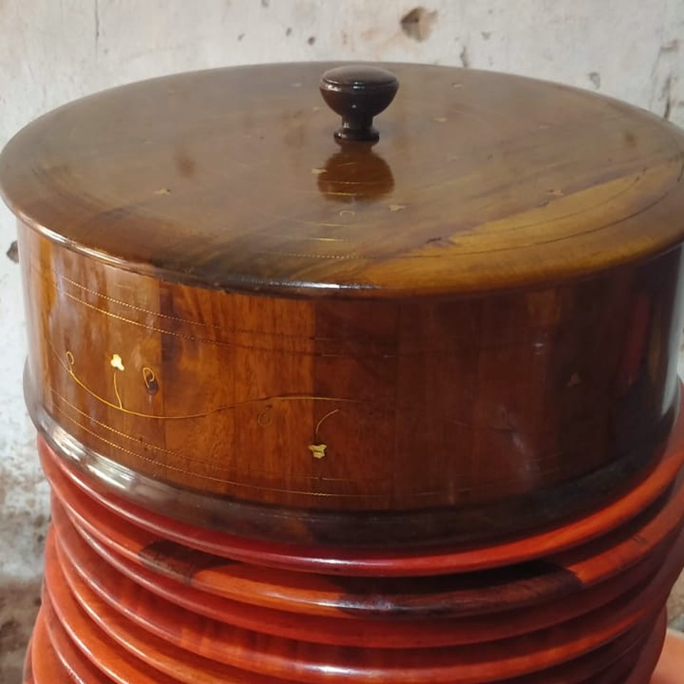 Twelve inch polished wooden hot pot with a domed lid and a turned knob, standing on stacked lacquered bases